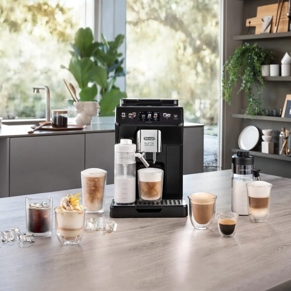De'Longhi Eletta Explore ECAM450.65.G Kaffeevollautomat in Grau, Ansicht in der Küche mit Milchkaraffen und Getränken