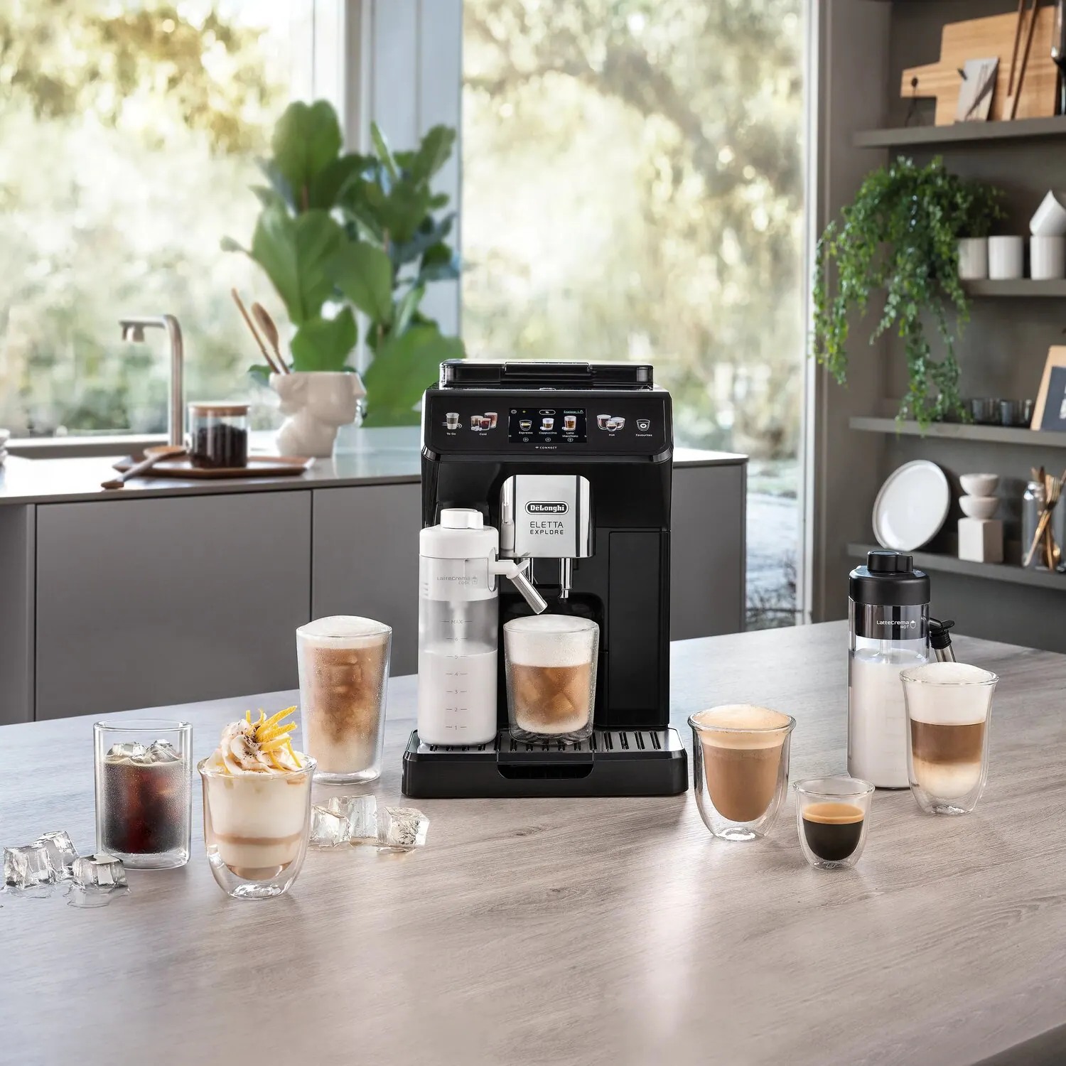 De'Longhi Eletta Explore ECAM450.65.G Kaffeevollautomat in Grau, Ansicht in der Küche mit Milchkaraffen und Getränken