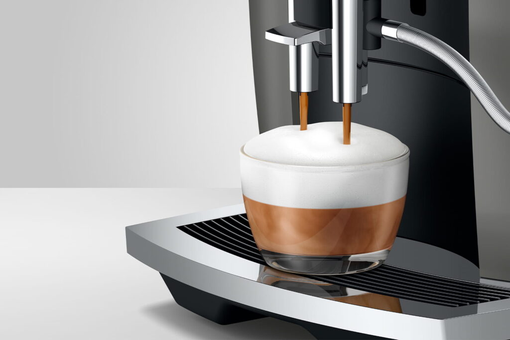 Jura E6 (EC) Kaffeevollautomat in Dark Inox, Detailansicht Cappuccino mit Milchschaum