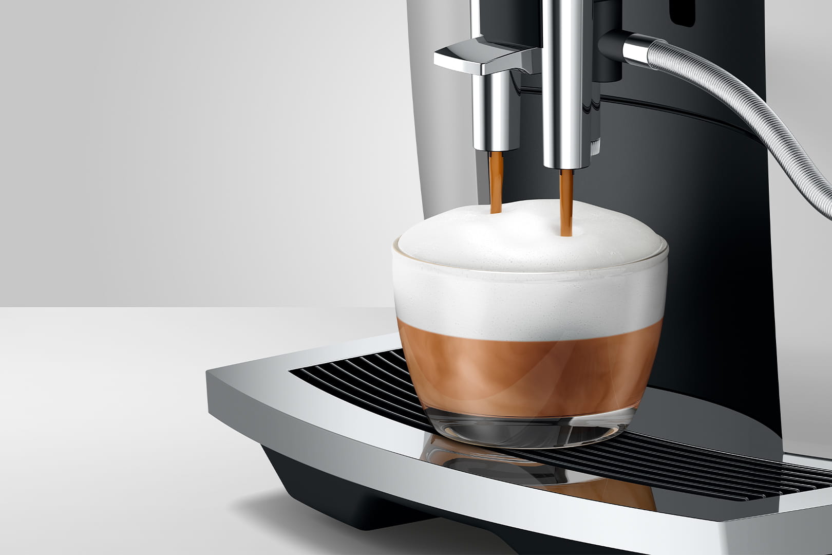 Jura E6 (EC) Kaffeevollautomat in Platin, Detailansicht Cappuccino mit Milchschaum