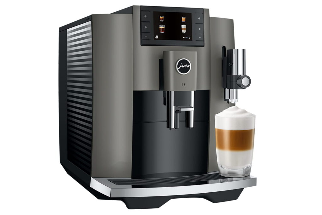 Jura E8 (EC) Kaffeevollautomat in Dark Inox, Seitenansicht schräg von vorn mit Latte macchiato