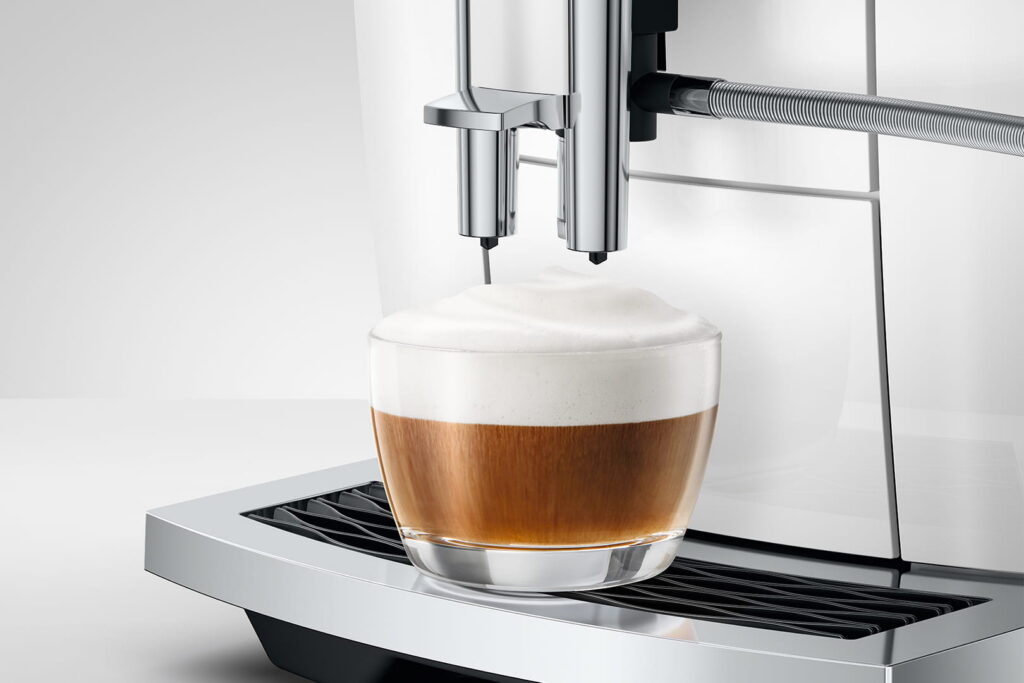 Jura E6 (ED) Kaffeevollautomat in Piano White, Detailansicht Cappuccino mit Milchschaum